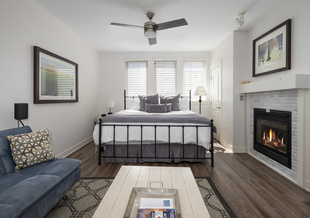 Unwind in your cozy suite where a crackling fireplace meets modern comfort, complete with plush seating and elegant furnishings for ultimate relaxation.