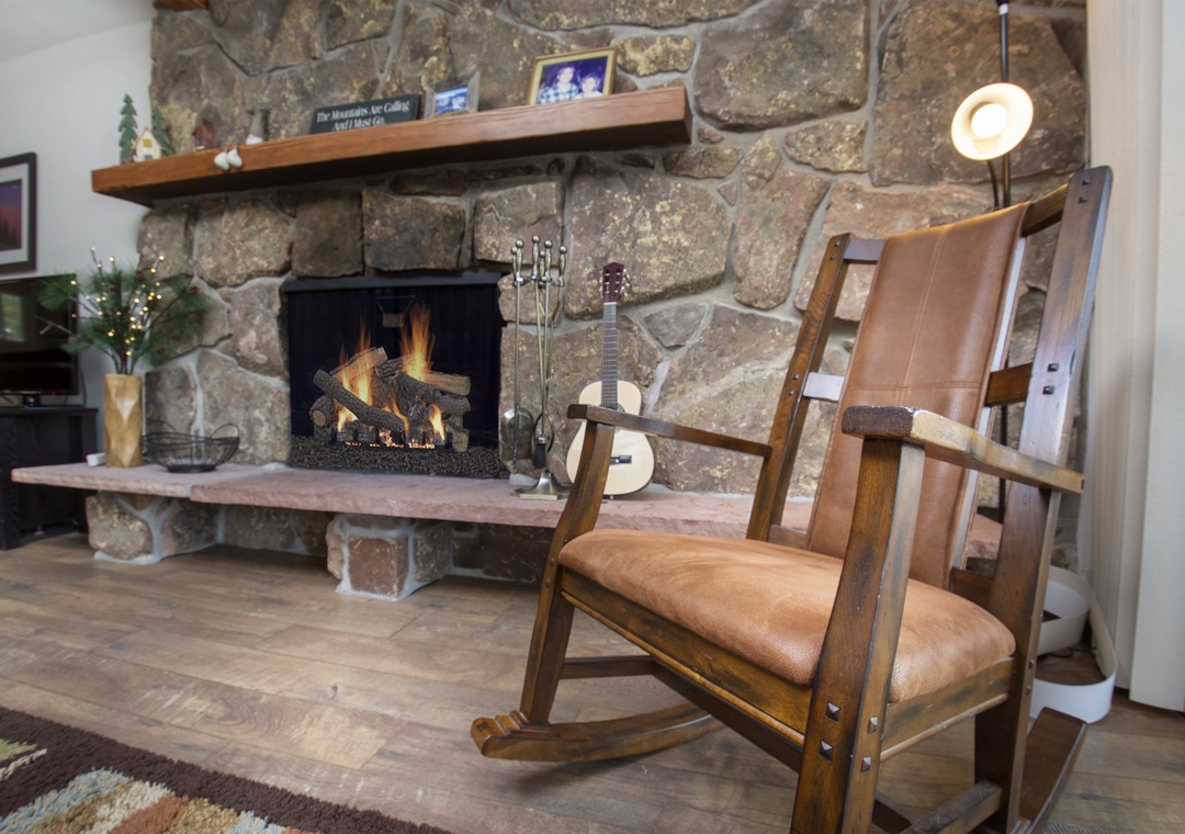 Settle into your cozy leather rocking chair beside the crackling stone fireplace for perfect evenings of warmth and relaxation.