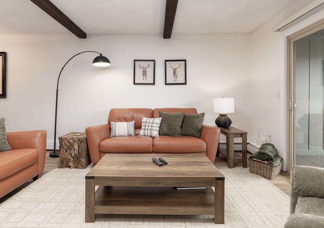 Unwind in your stylish living room with rich leather seating, exposed beams, and thoughtful touches that create the perfect mountain retreat atmosphere.