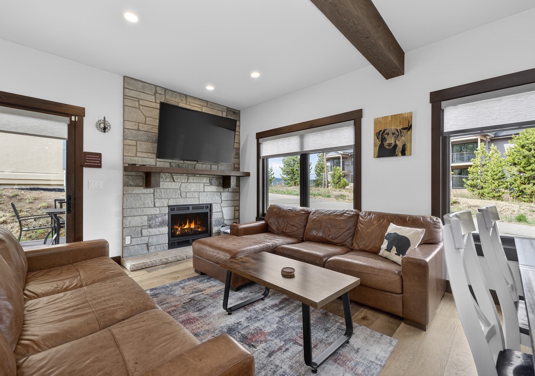 Settle into plush leather sofas by the warm fireplace, where rustic wood beams and mountain views through expansive windows create your perfect retreat.