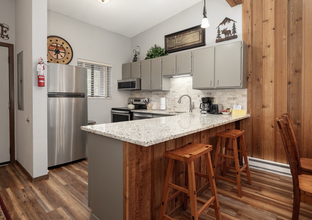 Your fully equipped kitchen features granite counters, stainless steel appliances, and cozy bar seating—perfect for morning coffee or casual meals together.