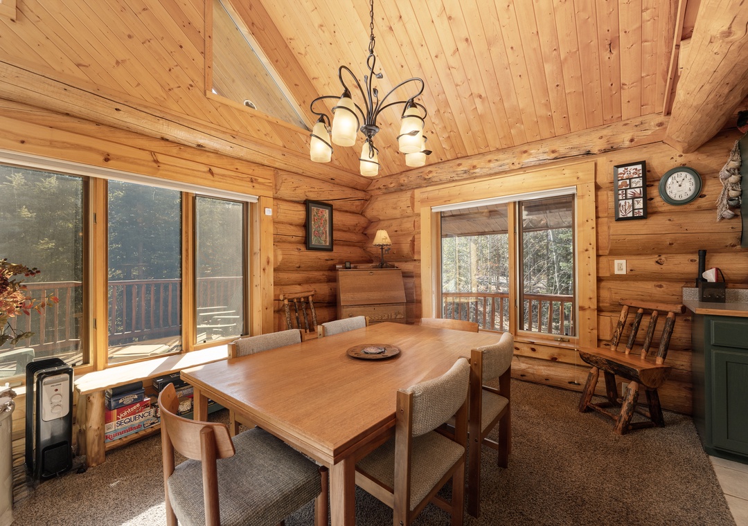 Gather around this warm dining space where rustic wood meets modern comfort, perfect for family meals with forest views.