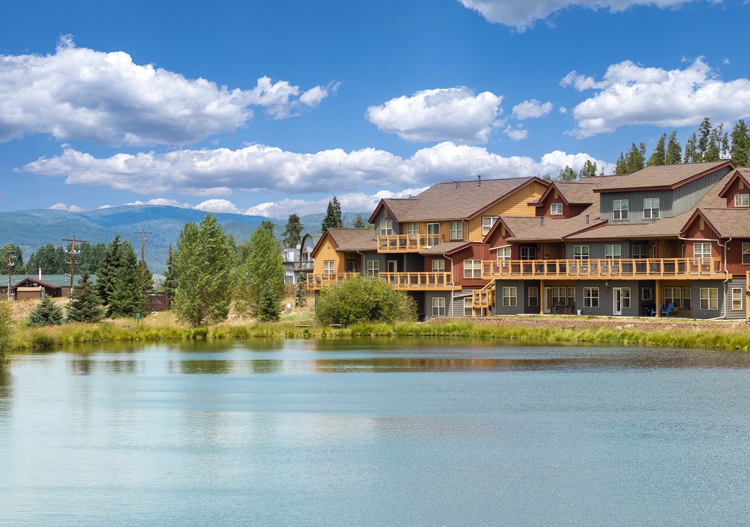 Charming multi-unit vacation property nestled alongside a tranquil pond with stunning mountain views and lush natural surroundings.