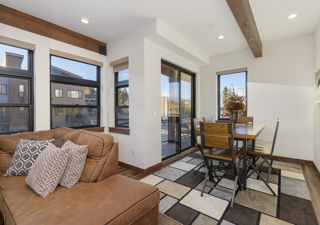 Relax in this bright, modern living space featuring exposed wood beams and a private balcony where you can unwind after exploring the area.