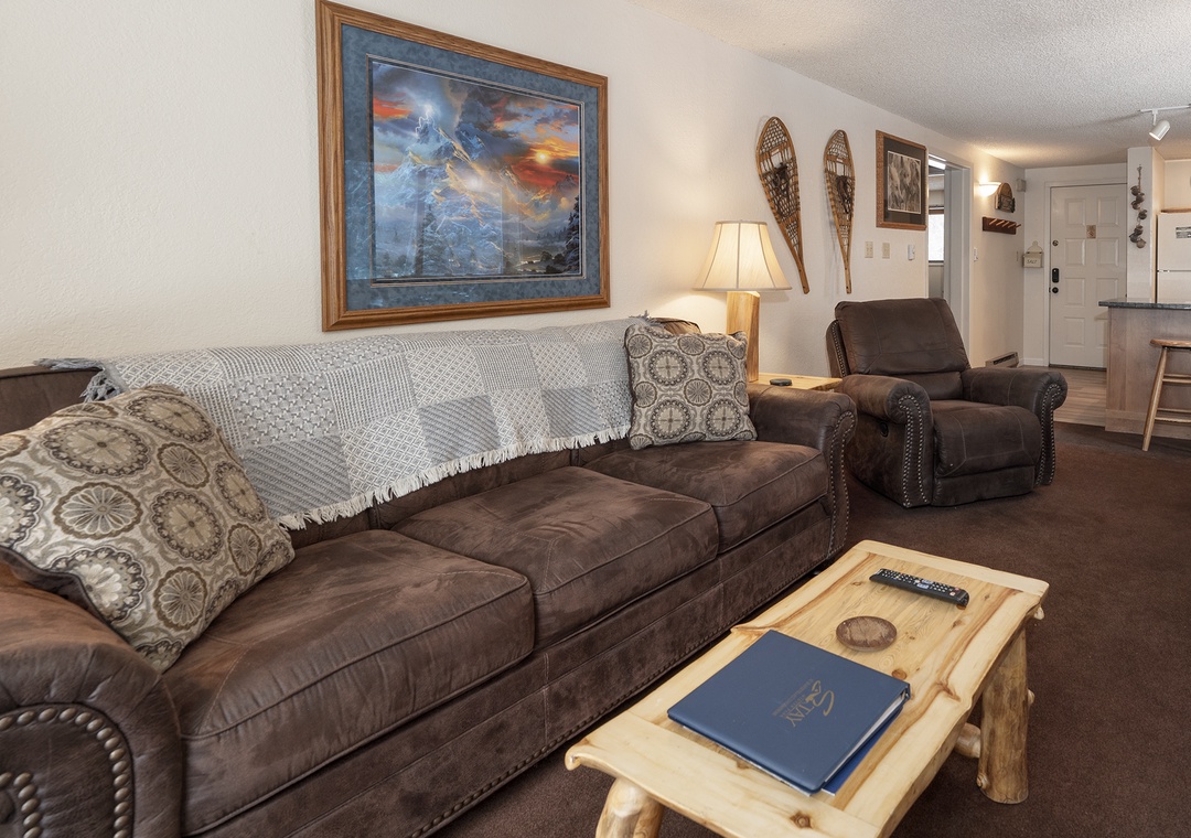 Sink into plush leather seating where rustic mountain artwork and warm lighting create your perfect retreat for evening relaxation.