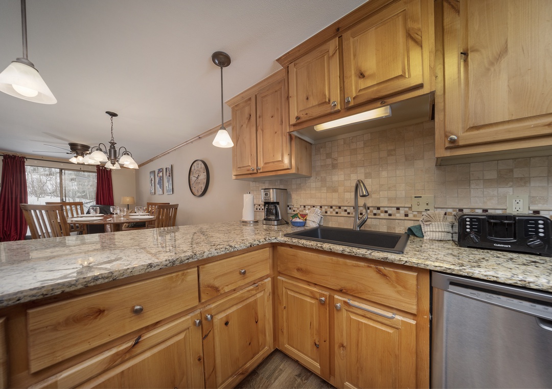 Your fully equipped kitchen features granite countertops and warm wood cabinets, perfect for preparing meals during your stay.