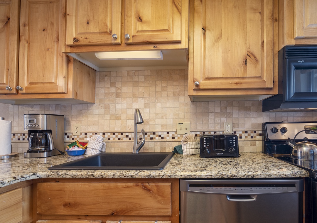 You'll love cooking in this fully equipped kitchen with warm wood cabinets, granite counters, and modern appliances ready for your culinary adventures.