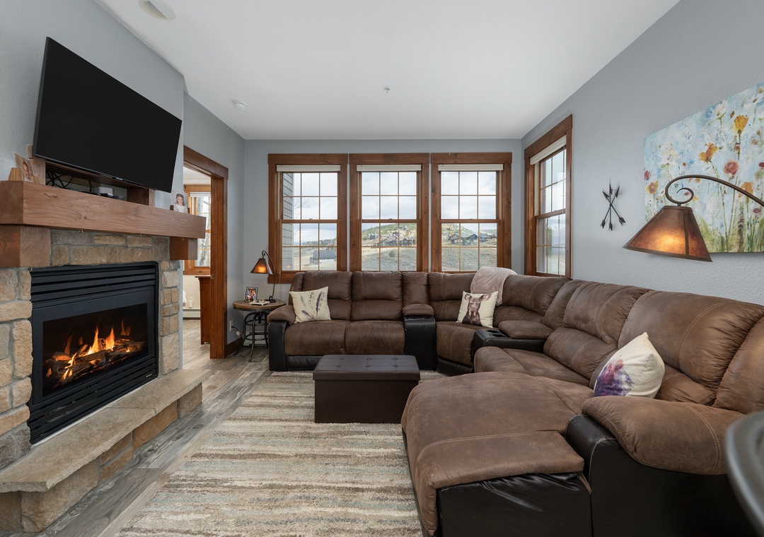Sink into the plush sectional sofa at Kicking Horse Buckskin 3-205 by your crackling stone fireplace, where warm flames and mountain views create the perfect retreat.