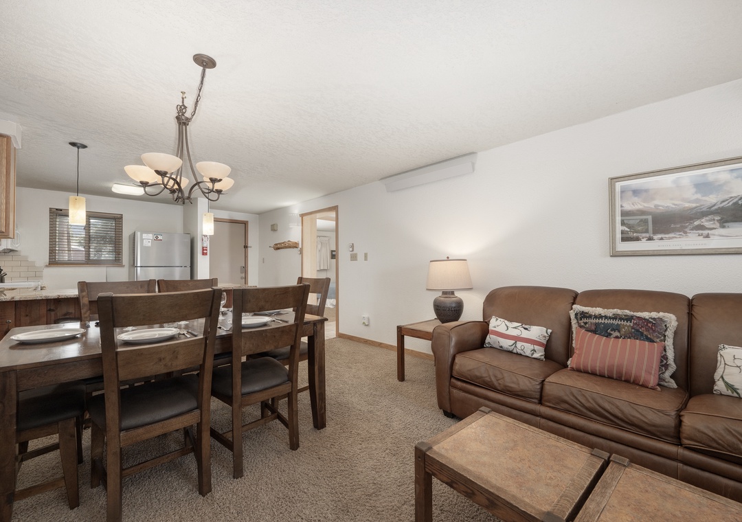 Settle into your spacious open-concept living area where warm leather seating and rustic wood dining create the perfect mountain retreat atmosphere.