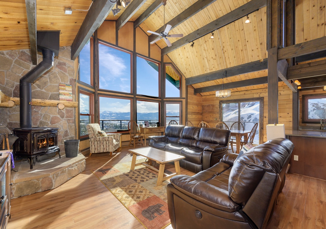 Cozy up in this stunning mountain retreat with soaring ceilings, leather seating, and breathtaking views through floor-to-ceiling windows.