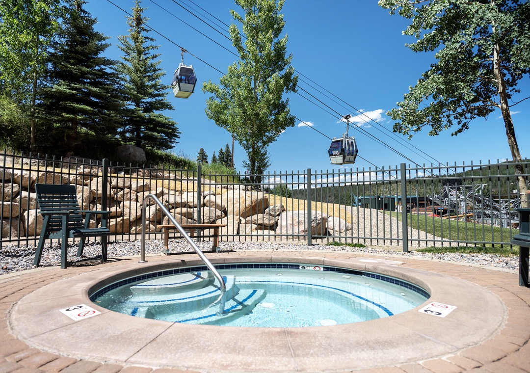 Luxurious hot tub in a mountain resort setting, with gondola lift access and scenic alpine views perfect for relaxation after a day of adventure.