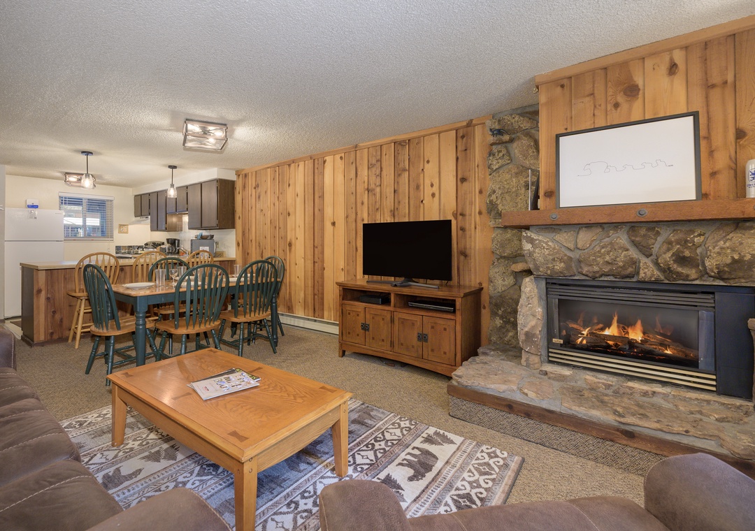 Cozy up by your stone fireplace in this warm living space with rustic wood accents and open kitchen for mountain memories.