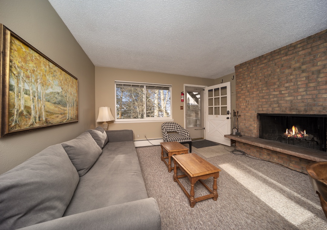 Cozy up by the crackling fireplace while natural light streams through windows, creating the perfect space for your relaxing getaway.