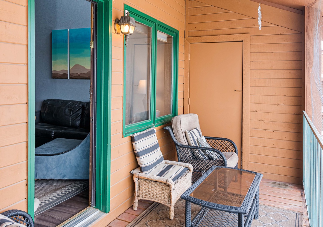 Unwind on your private balcony at 643 SilverCreek Inn with comfy seating and charming green-trimmed doors leading into your cozy retreat.