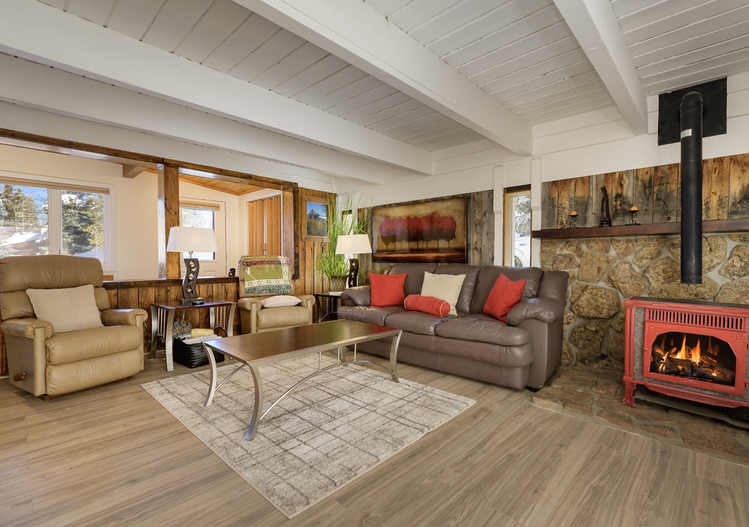 Cozy up by your crackling fireplace in this inviting living space with rustic beams and mountain views.