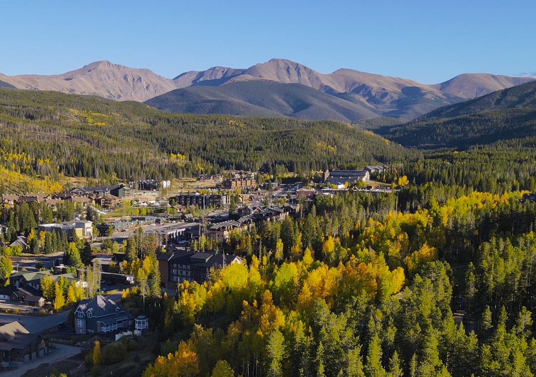 Nestled in a mountain valley, this scenic community is surrounded by evergreen forest and golden aspen trees with majestic peaks rising in the distance.