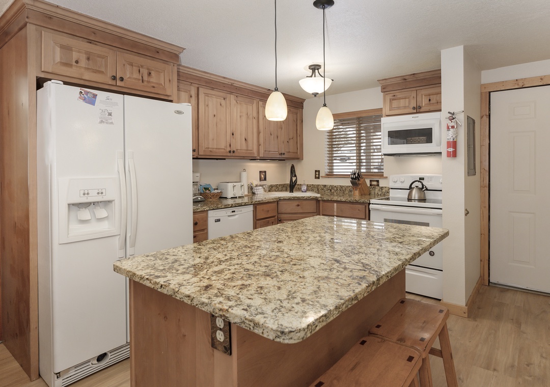 Your fully equipped kitchen features granite countertops, warm wood cabinets, and modern appliances for memorable home-cooked meals.