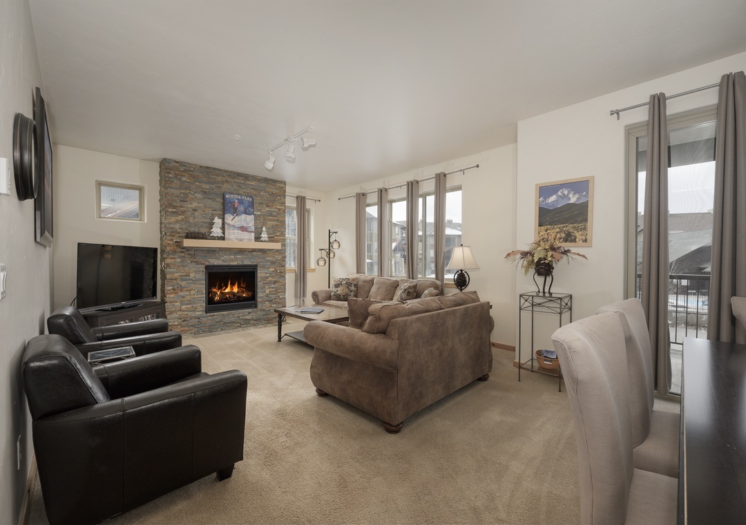Unwind in your spacious living room with crackling fireplace, plush seating, and mountain views through expansive windows.