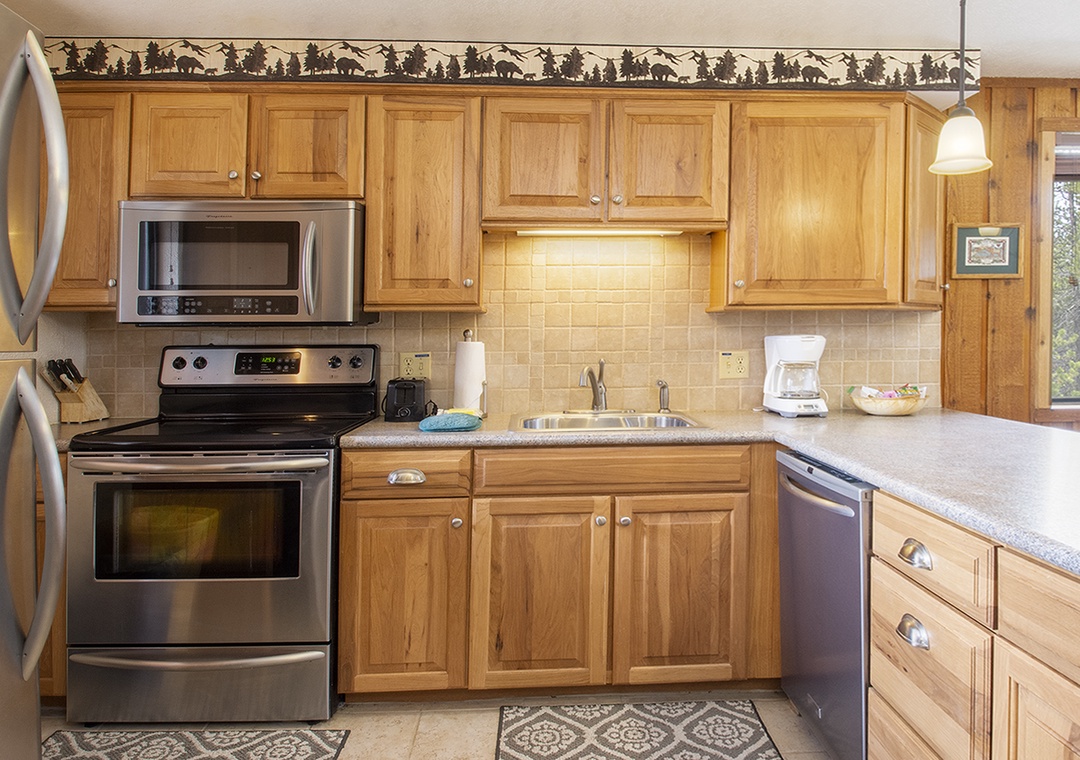 Your fully equipped kitchen features stainless steel appliances and warm wood cabinetry, perfect for preparing memorable meals during your stay.