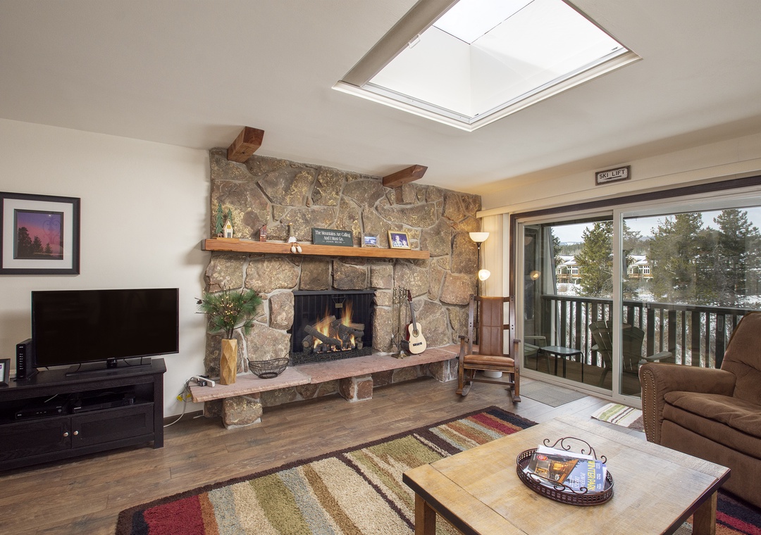 Cozy up by your stone fireplace while natural light pours through the skylight, creating the perfect mountain retreat atmosphere.