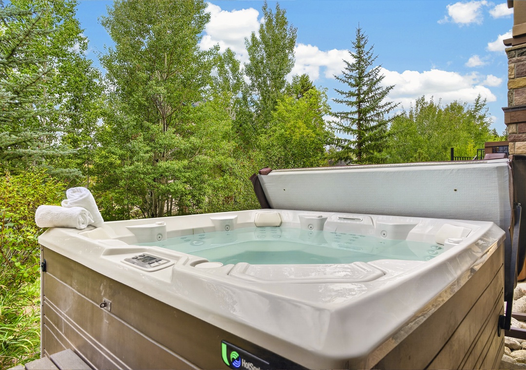 Soak in the warm bubbles as you gaze out at lush summer greenery under a bright blue sky—pure relaxation awaits you in this private outdoor hot tub.
