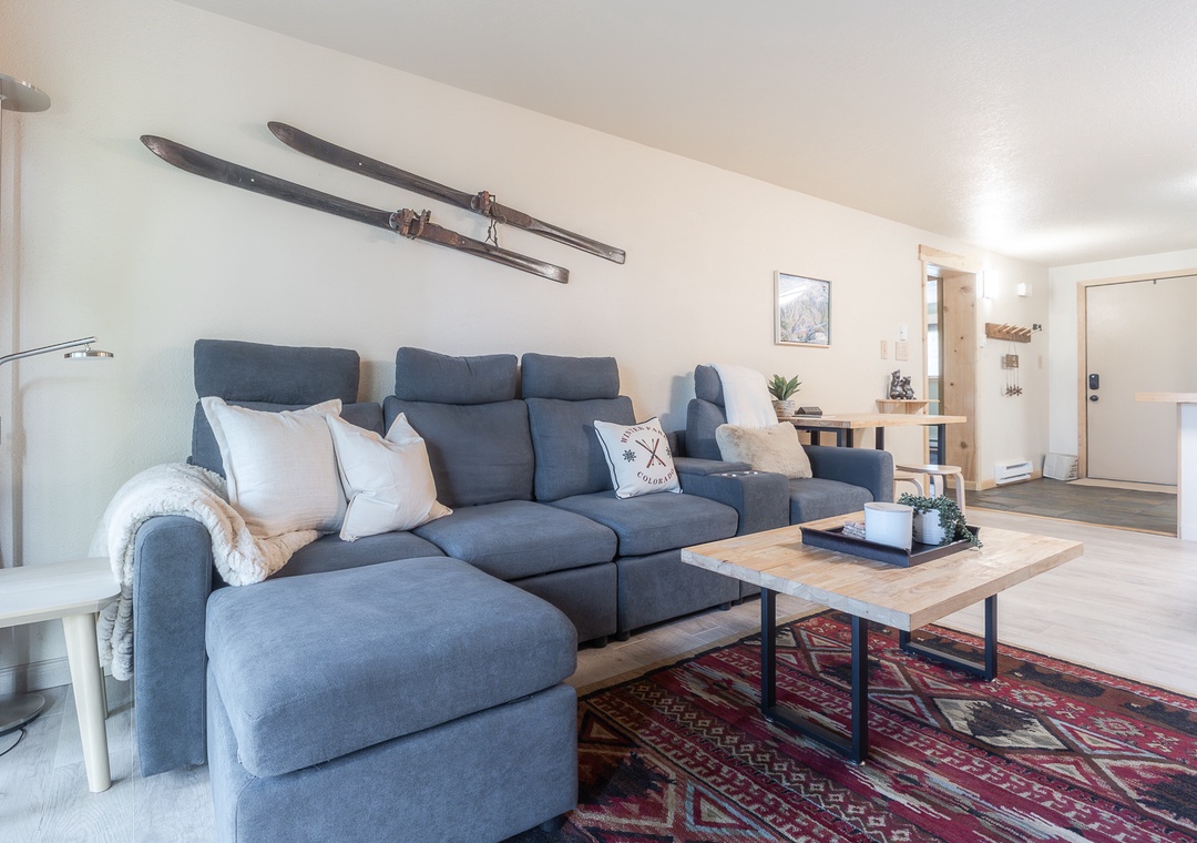 Unwind on the plush sectional sofa while admiring vintage ski decor that adds alpine charm to your bright, modern living space.