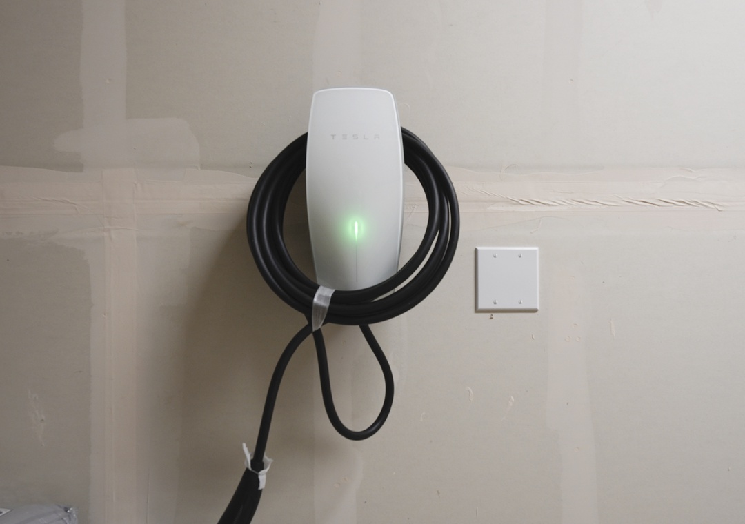 An electric vehicle charging station is mounted and ready for use in the parking area, ensuring your arrival is smooth and your vehicle stays powered throughout your stay.