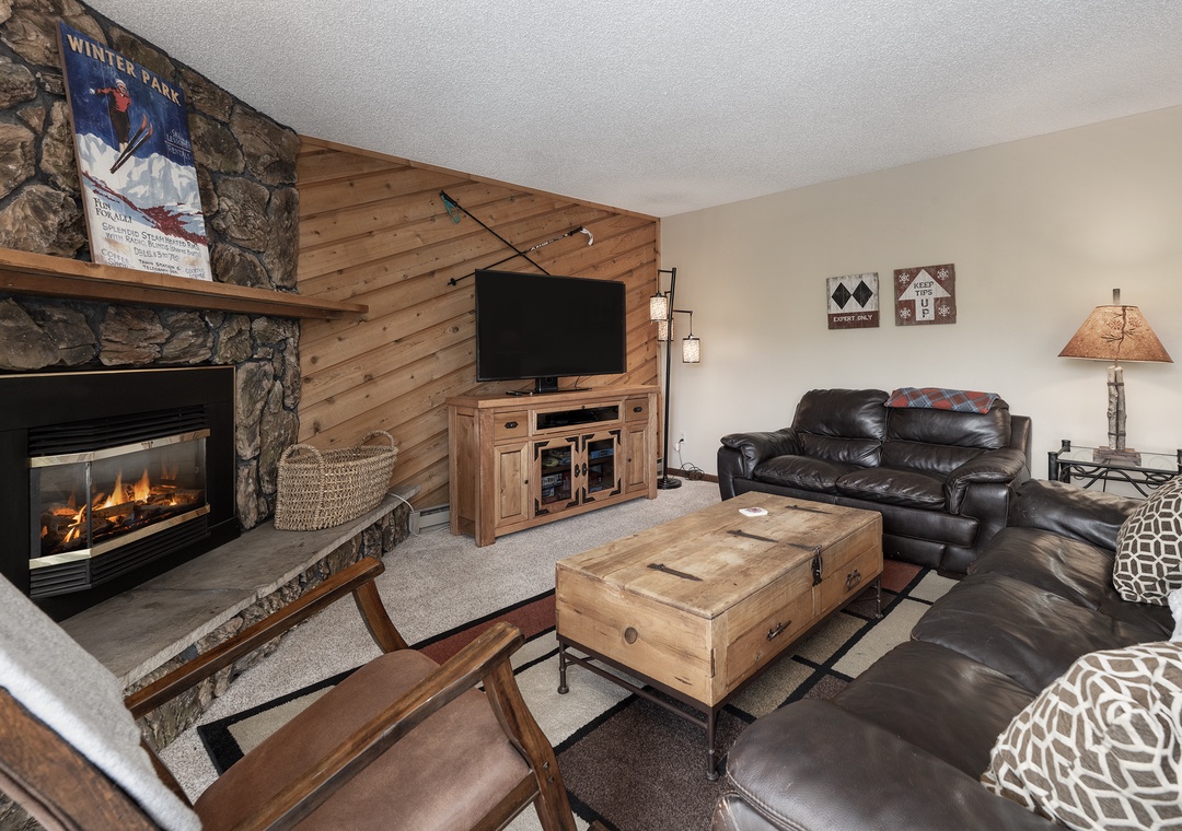 Cozy up by your crackling fireplace while watching your favorite shows in this welcoming living room with rustic charm.