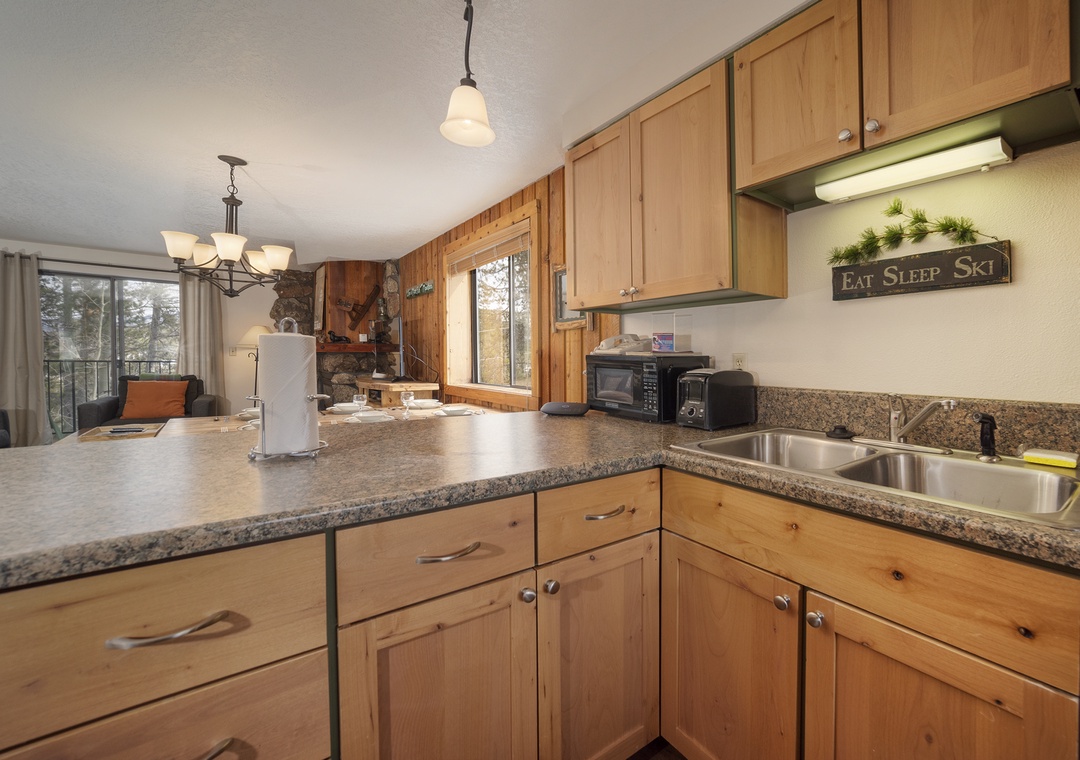 Your fully equipped kitchen features granite countertops and warm wood cabinets, perfect for preparing meals after your mountain adventures.