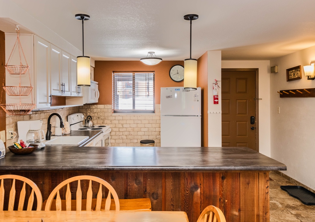 Your fully equipped kitchen features warm wood counters, modern appliances, and pendant lighting—perfect for preparing meals during your stay.