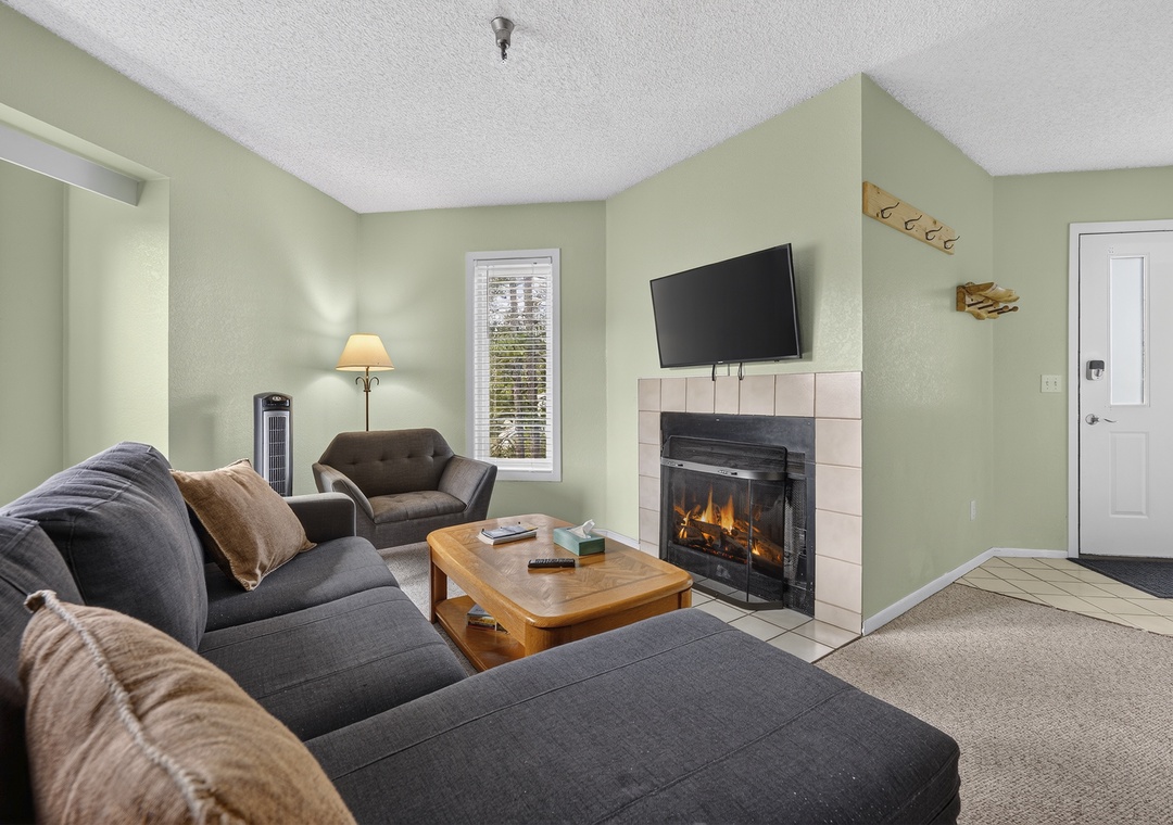 Sink into plush sofas by the warm glow of your own fireplace. Soft greens and cozy textures make this living room the perfect spot to unwind after a day of adventure.
