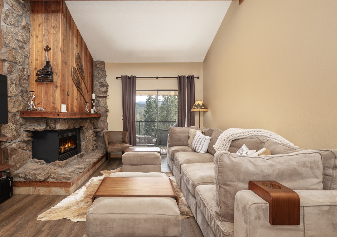 Curl up on plush seating by your crackling stone fireplace, watching flames dance while forest views frame your cozy mountain retreat.