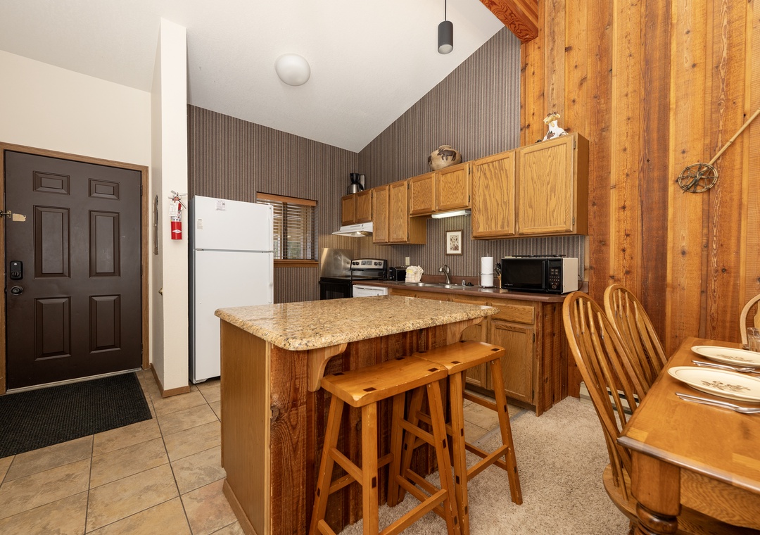 Prepare your favorite meals in this warm, wood-paneled kitchen with granite counters and everything you need for a cozy mountain retreat.