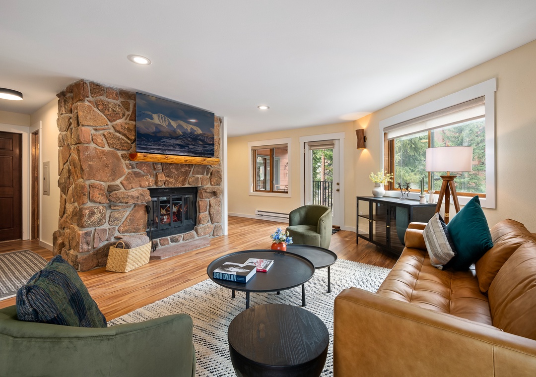 Sink into plush leather seating by your crackling stone fireplace, where mountain views and warm lighting create the perfect retreat.