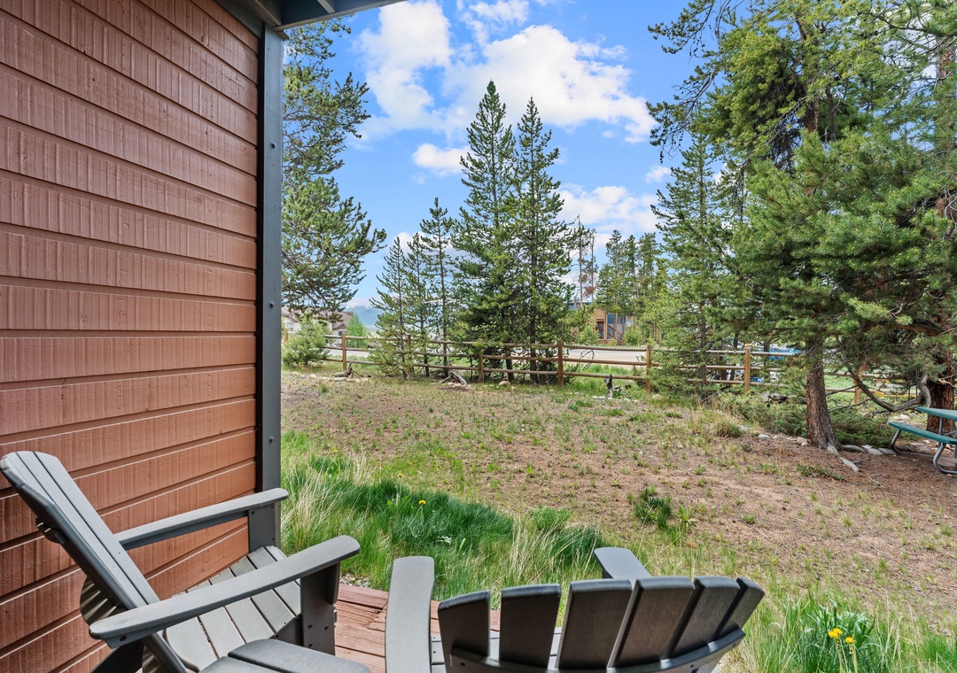 A private mountain retreat nestled among towering pines, offering serene views and peaceful outdoor space near a neighboring property.