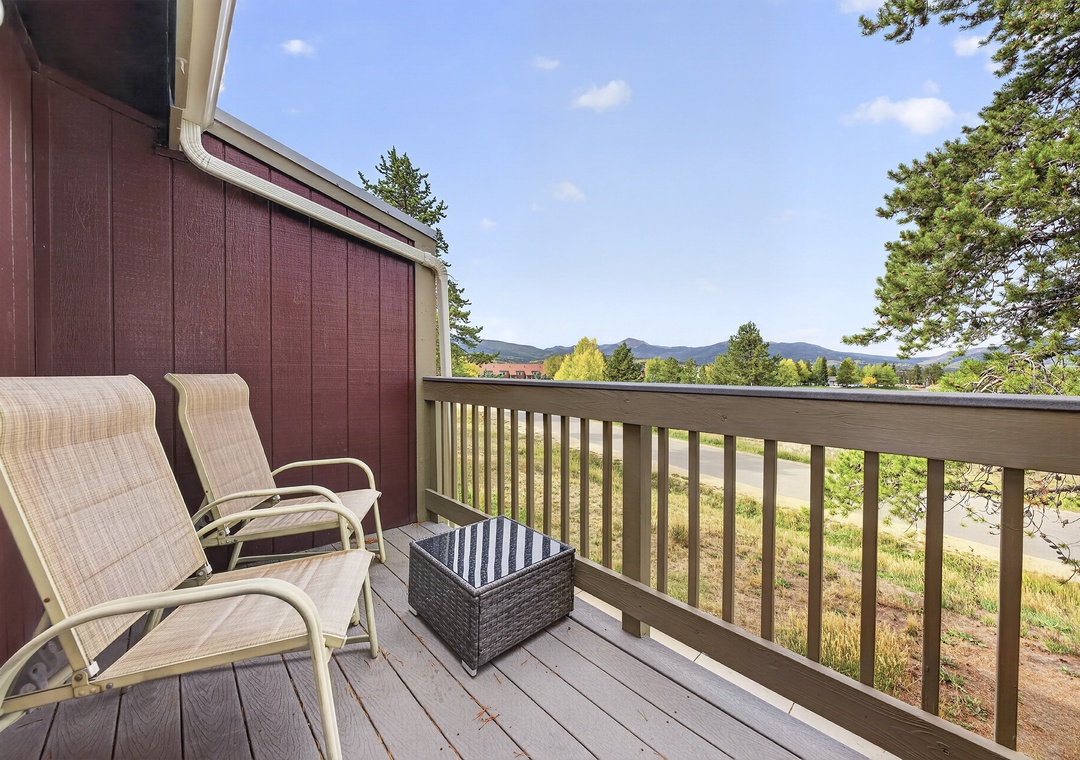 Settle into your private balcony and soak up breathtaking mountain views framed by tall pines, with cozy lounge chairs perfectly positioned for morning coffee or evening relaxation.