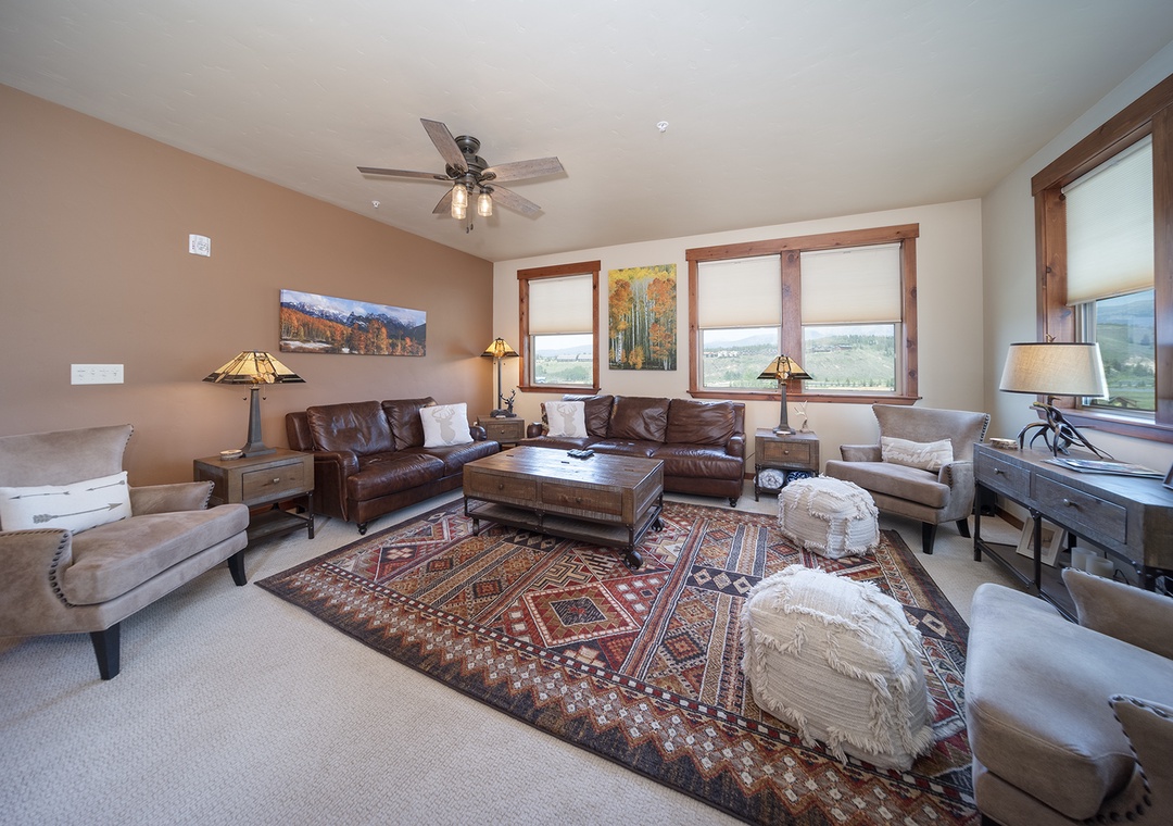 Sink into rich leather sofas surrounded by warm wood tones and mountain views from your spacious living room retreat.