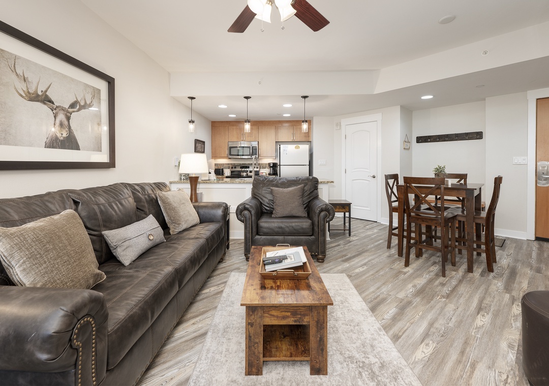 Relax in your stylish open-concept space with rich leather seating, rustic wood accents, and a fully equipped kitchen perfect for home-cooked meals.