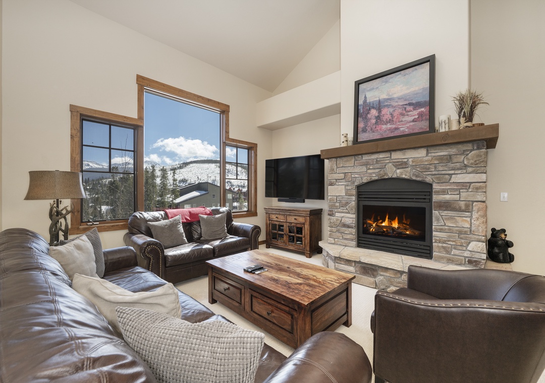 Cozy up in your living room with mountain views, crackling fireplace, and luxurious leather seating perfect for après-ski relaxation.