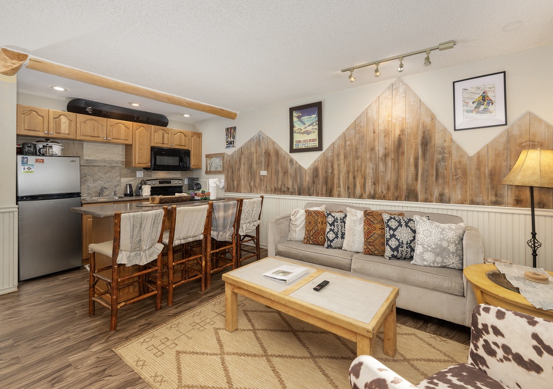 Unwind in your cozy mountain retreat with rustic wood accents, a fully equipped kitchen, and comfortable seating perfect for après-ski relaxation.