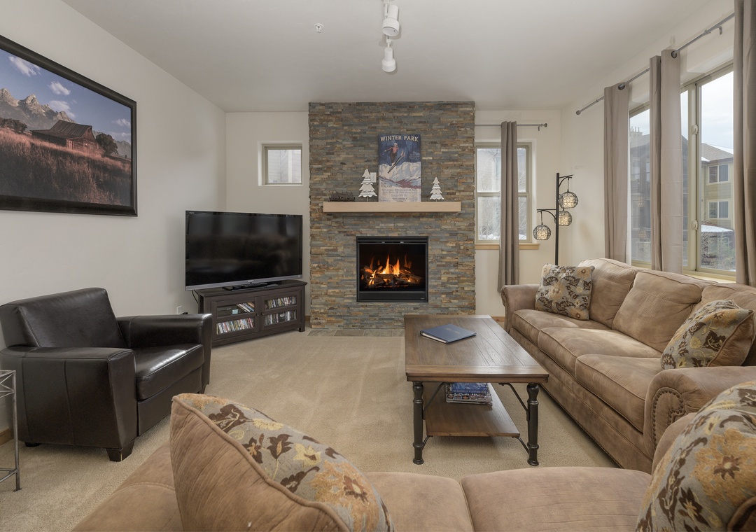 Cozy up by the crackling fireplace while watching your favorite shows on the large flat-screen TV in this welcoming living room.