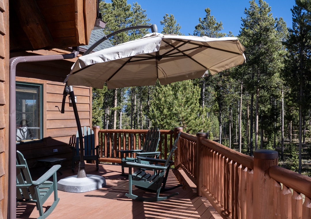 Relax on your private deck surrounded by towering pines. Comfortable seating and shade umbrella create your perfect outdoor retreat.