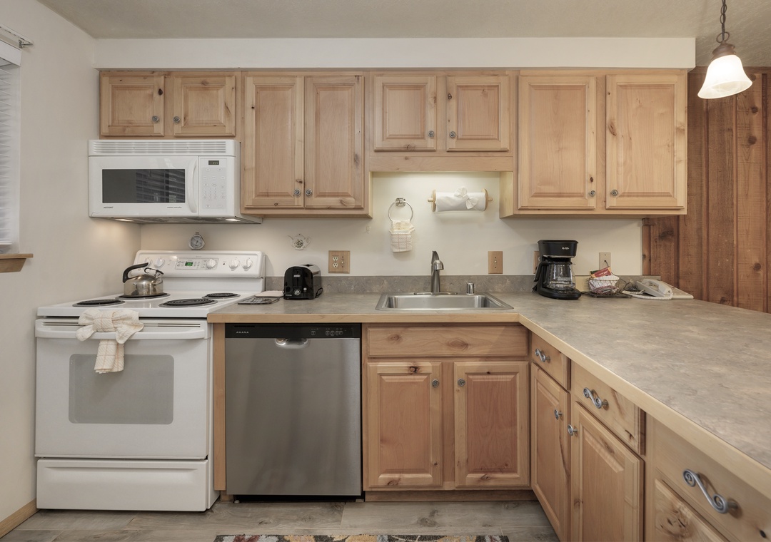 Your fully equipped kitchen awaits with warm wood cabinets, modern appliances, and everything needed for home-cooked meals during your stay.
