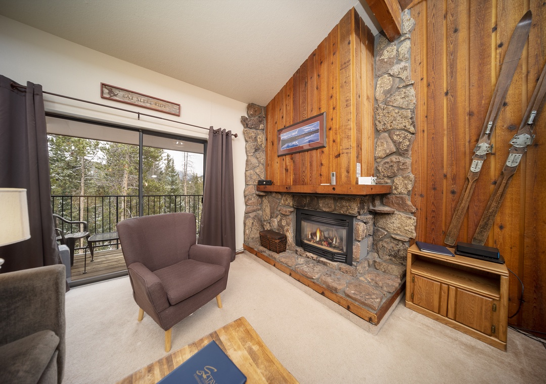 Warm up by your stone fireplace in this cozy mountain retreat, with rustic wood walls and serene forest views from your private balcony.