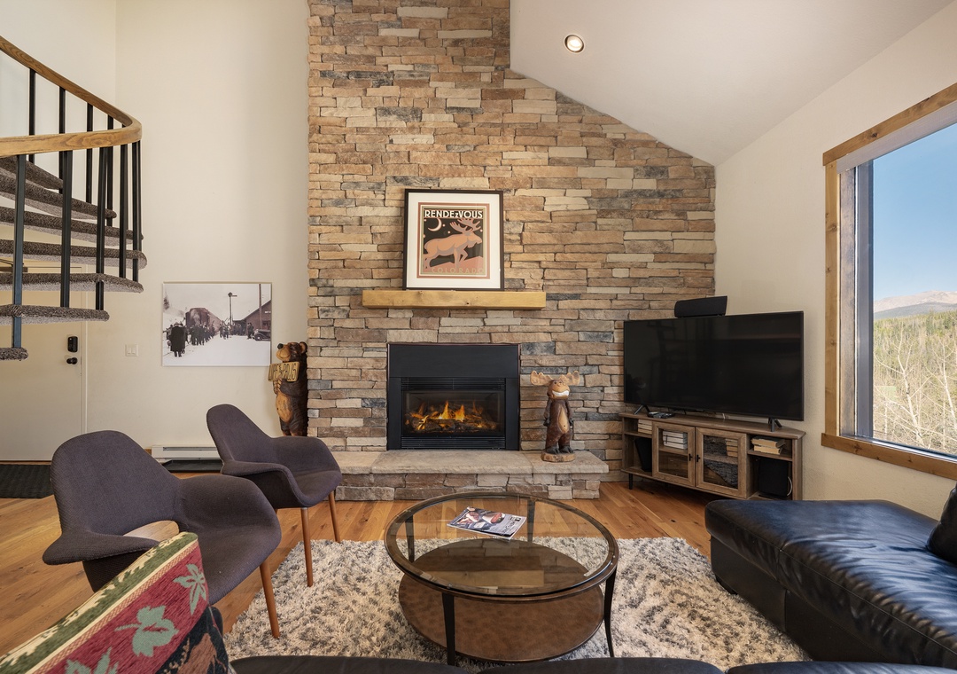 Cozy up by your stone fireplace while mountain views stretch beyond the windows in this stylish living room.