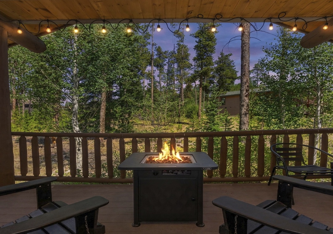 Gather under twinkling lights on your private covered deck, where a crackling fire pit invites cozy evening conversations surrounded by towering pines and mountain tranquility.