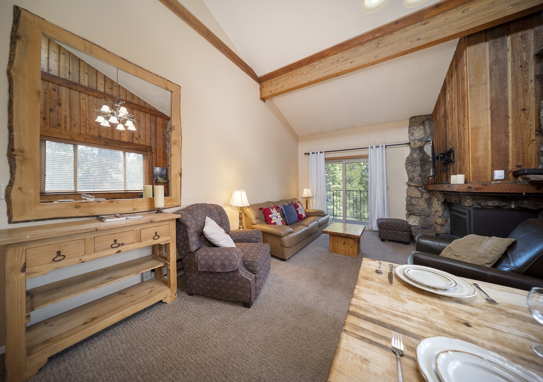 Unwind in your cozy mountain retreat with exposed beams, stone fireplace, and comfortable seating where rustic charm meets modern comfort.