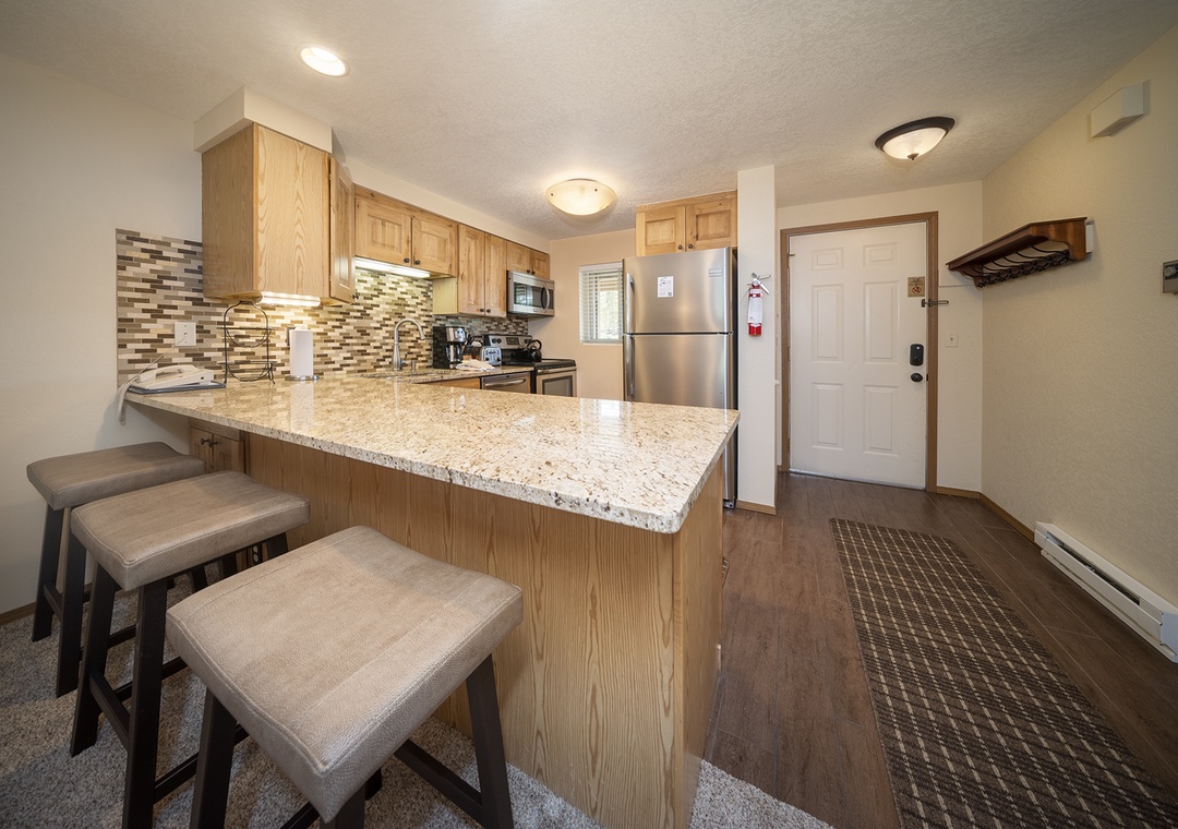 Your fully equipped kitchen features granite countertops, modern appliances, and a breakfast bar where you can enjoy morning coffee.