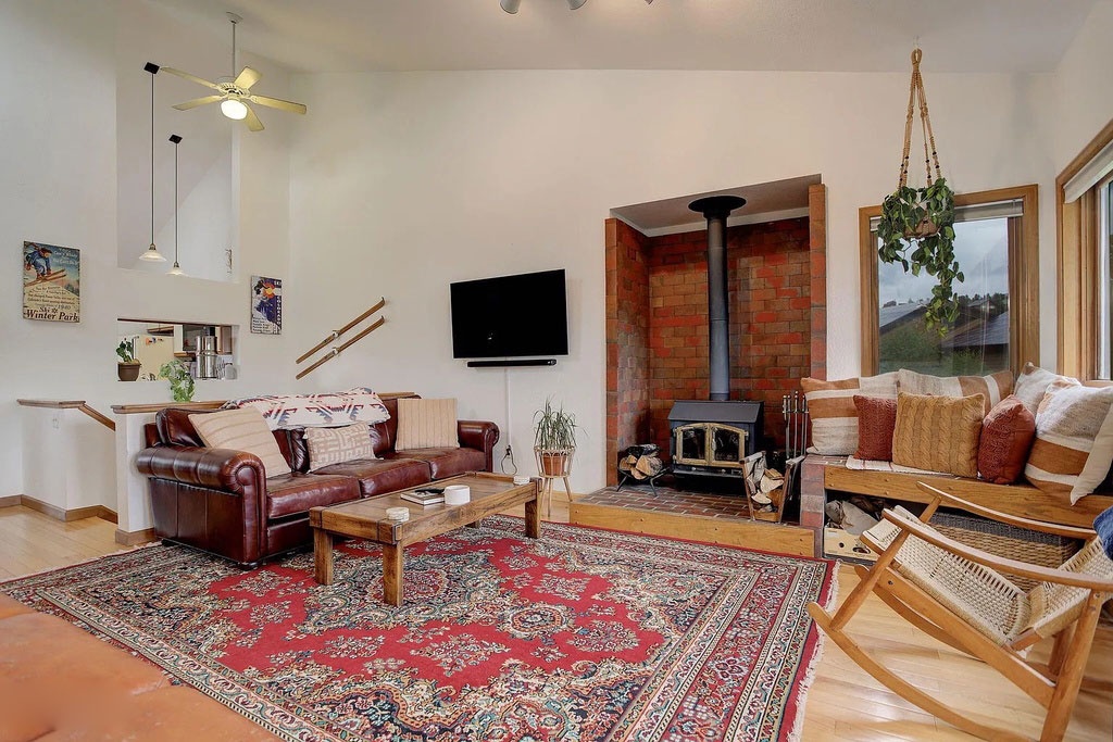 Curl up in this warm living room with leather seating, cozy fireplace, and mountain views from large windows.