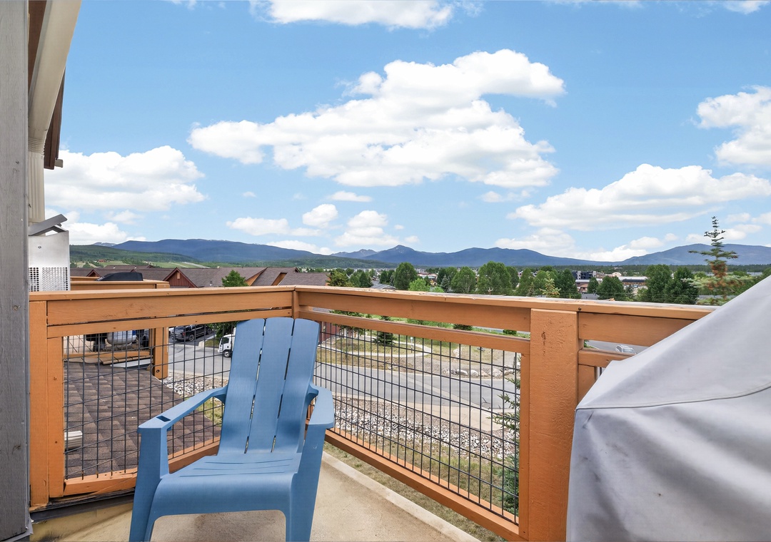 The property features a balcony offering sweeping mountain vistas, lush greenery, and clear blue skies—a peaceful arrival setting framed by scenic natural surroundings.